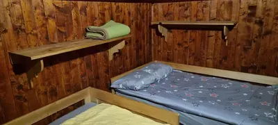 a room with two bunk beds in a cabin at Koča Pastirica - Velika planina in Stahovica