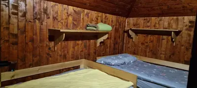 a room with a bed in a wooden cabin at Koča Pastirica - Velika planina in Stahovica