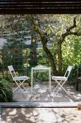 two chairs and a table in front of a tree at Ljubljana C17 4-Bedroom Private Row House with Garden and Parking in Ljubljana