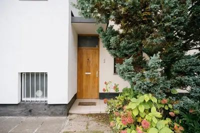 a building with a wooden door and some plants at Ljubljana C17 4-Bedroom Private Row House with Garden and Parking in Ljubljana