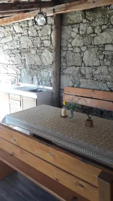 a room with a table and a stone wall at Apartma Sterle in Stari Trg pri Ložu