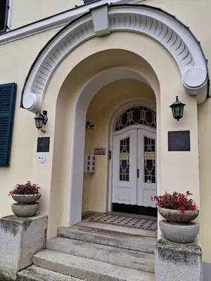 an archway leading to a white door with two flower pots at VILLA GOLF Crystal Drop Apartment in Rogaška Slatina