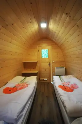 two beds in a log cabin with a door at Grajski oddih in Cerklje na Gorenjskem