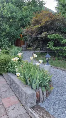 a garden with flowers and a stone pathway at Grajski oddih in Cerklje na Gorenjskem