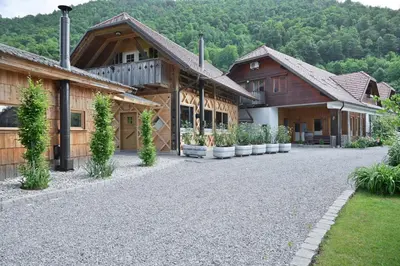 a group of wooden buildings with a gravel driveway at Grajski oddih in Cerklje na Gorenjskem