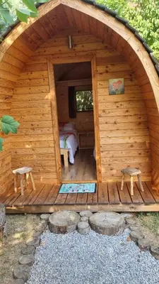 a wooden cabin with two stools in the doorway at Grajski oddih in Cerklje na Gorenjskem