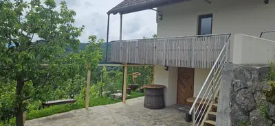 a house with a balcony and a tree at Zidanica Muhič in Dolenjske Toplice