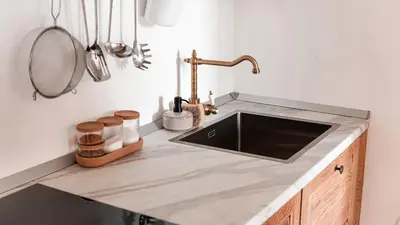 a kitchen counter with a sink and a mirror at Zidanica Muhič in Dolenjske Toplice