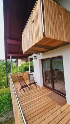 two chairs on a wooden deck on a house at Zidanica Muhič in Dolenjske Toplice