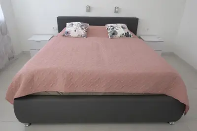 a bed with two pillows on it in a bedroom at Martinka apartments in Jelšane