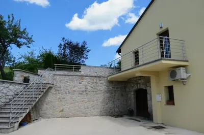a house with a staircase on the side of it at Martinka apartments in Jelšane