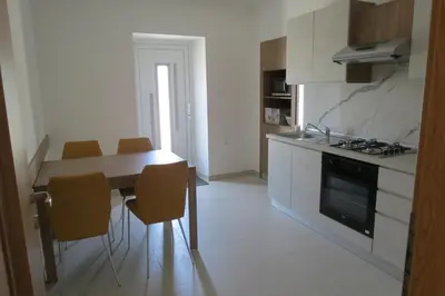 a kitchen with a table and chairs and a stove at Martinka apartments in Jelšane