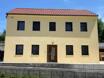 a yellow house with a red roof and a door at Martinka apartments in Jelšane
