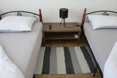 two beds in a room with a table between them at Martinka apartments in Jelšane