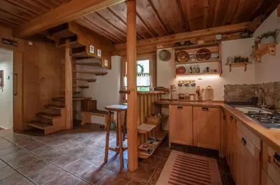 a kitchen with wooden cabinets and a spiral staircase at Boutique House Vresje in Bohinjska Bistrica