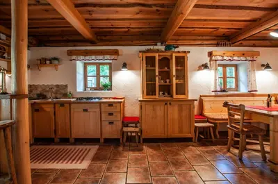 a kitchen with wooden cabinets and a table at Boutique House Vresje in Bohinjska Bistrica