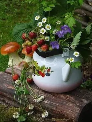a white vase with flowers and strawberries on a log at Boutique House Vresje in Bohinjska Bistrica