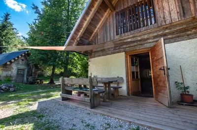 a wooden porch with a wooden table and a wooden door at Boutique House Vresje in Bohinjska Bistrica