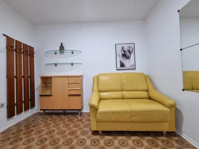 a yellow chair in a room with a cabinet at Apartma DOMA in Tolmin