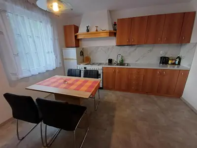 a kitchen with a wooden table and a table and chairs at Apartma DOMA in Tolmin