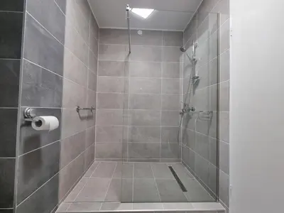 a bathroom with a shower with a glass door at Apartma DOMA in Tolmin