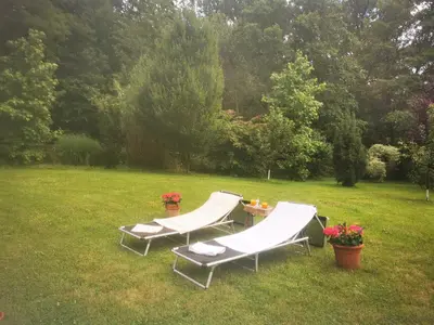 two lounge chairs and a table in a field at Holiday Home - Goričko Park in Kobilje