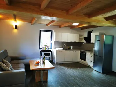 a kitchen and living room with a couch and a refrigerator at Holiday Home - Goričko Park in Kobilje
