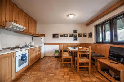 a kitchen with wooden cabinets and a table and chairs at Veduta Apartment Bohinj Lake in Bohinj