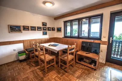 a dining room with a table and a television at Veduta Apartment Bohinj Lake in Bohinj