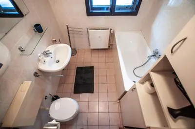 a bathroom with a sink and a tub and a toilet at Veduta Apartment Bohinj Lake in Bohinj