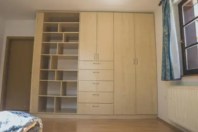 a bedroom with a large wooden cabinet with drawers at Apartment Amak with free onsite parking in Bovec