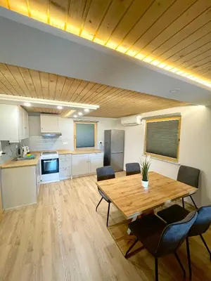 a kitchen and dining room with a wooden table and chairs at Čebelnk: sanjska hišica 4 km od Bleda in Lesce