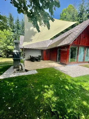 a red barn with a grill in the yard at Čebelnk: sanjska hišica 4 km od Bleda in Lesce