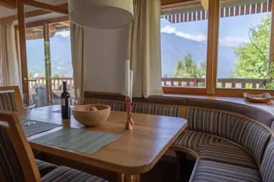 a wooden table with a candle and a bottle of wine at Apartments Vila Jelka in Bohinj