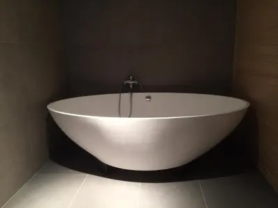 a white bath tub in a bathroom with a wall at Apartments Vila Jelka in Bohinj