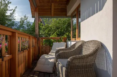 a patio with wicker chairs on a porch at Apartments Vila Jelka in Bohinj