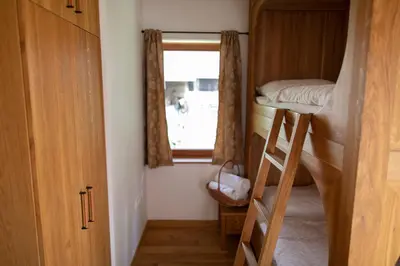 a small room with two bunk beds and a window at Apartments Vila Jelka in Bohinj