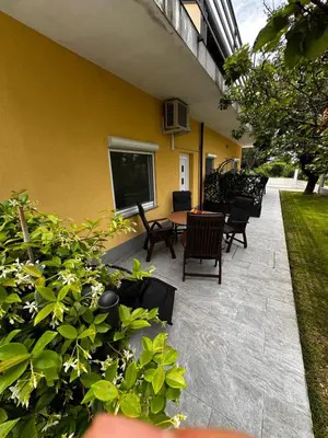 a patio with chairs and a table next to a building at RIAD Apartments in Zgornje Škofije