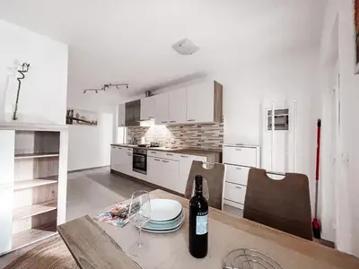 a kitchen with a table with a bottle of wine at RIAD Apartments in Zgornje Škofije