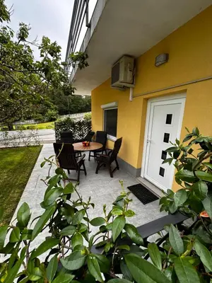 a patio with a table and chairs next to a building at RIAD Apartments in Zgornje Škofije