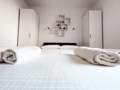 a white bedroom with two beds and towels on the bed at RIAD Apartments in Zgornje Škofije