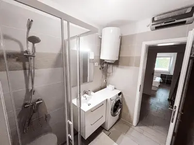 a bathroom with a washing machine and a sink at RIAD Apartments in Zgornje Škofije