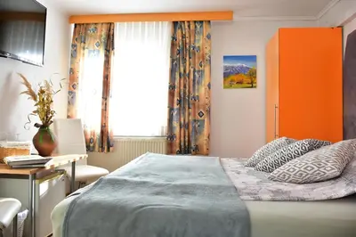 a bedroom with a bed and a desk and a window at Sobe - Rooms Stremljan Ljubljana in Medvode