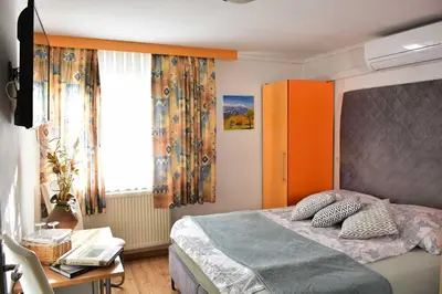 a bedroom with a bed and a desk and a window at Sobe - Rooms Stremljan Ljubljana in Medvode