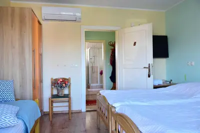 a bedroom with two beds and a chair and a window at Sobe - Rooms Stremljan Ljubljana in Medvode