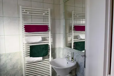 a bathroom with a sink and a mirror and towels at Sobe - Rooms Stremljan Ljubljana in Medvode