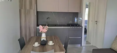 a kitchen with a table with a vase of flowers on it at Camp Velenje in Velenje