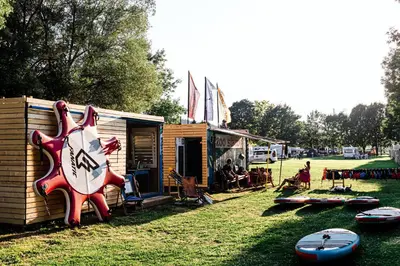 a house with a sign on it next to some surfboards at Camp Velenje in Velenje