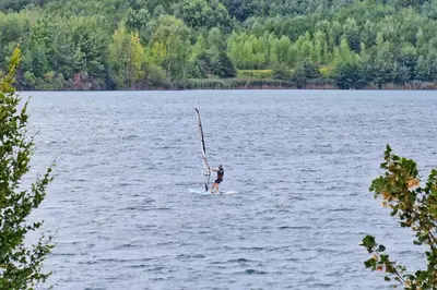 a person on a paddle board in a lake at Camp Velenje in Velenje