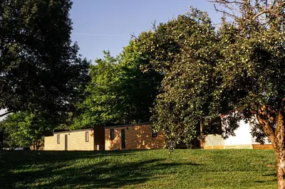 a building in the middle of a field with trees at Camp Velenje in Velenje